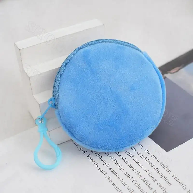 Round, blue, plush coin purse with zipper and loop.