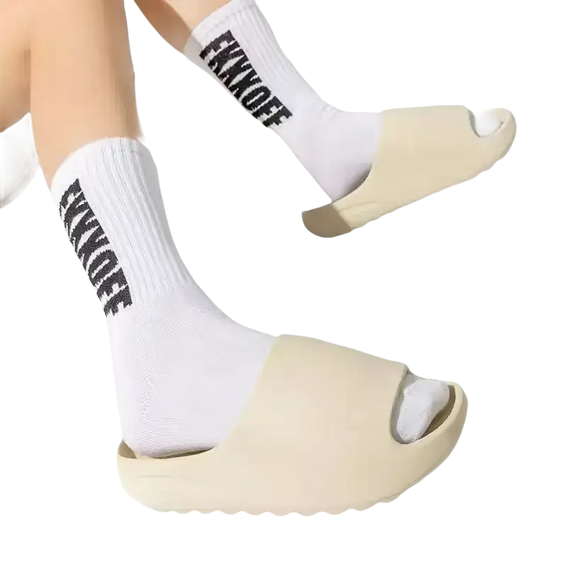 Beige slide sandals with white socks.