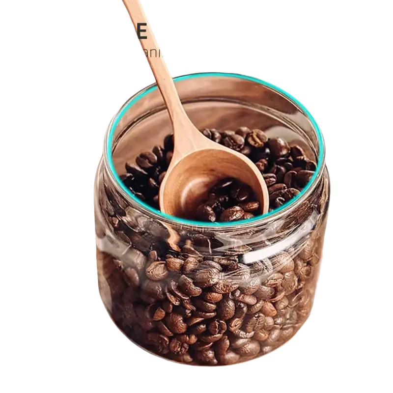 Coffee beans in a glass jar with a wooden spoon.