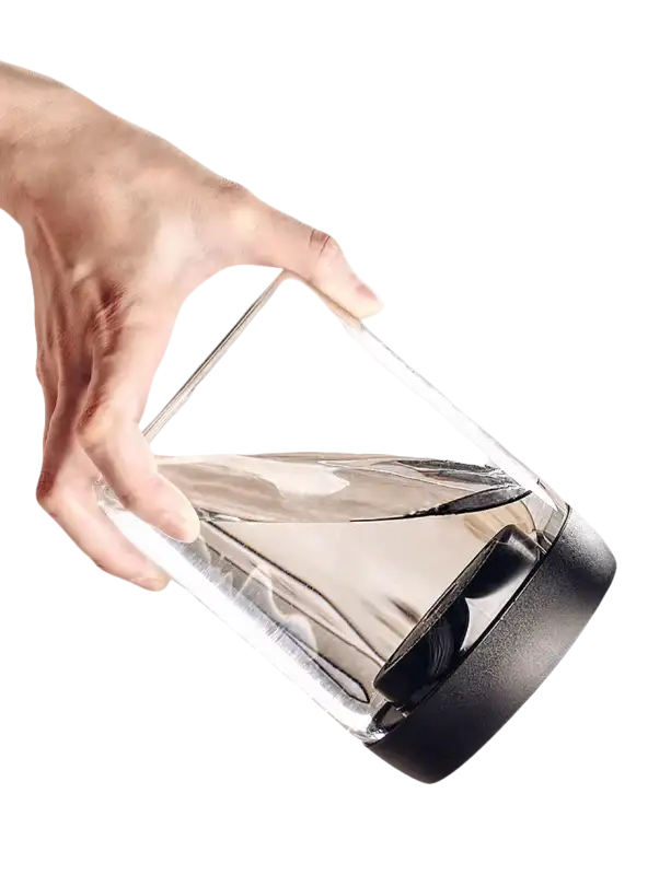 Tilted glass container with black lid and water.