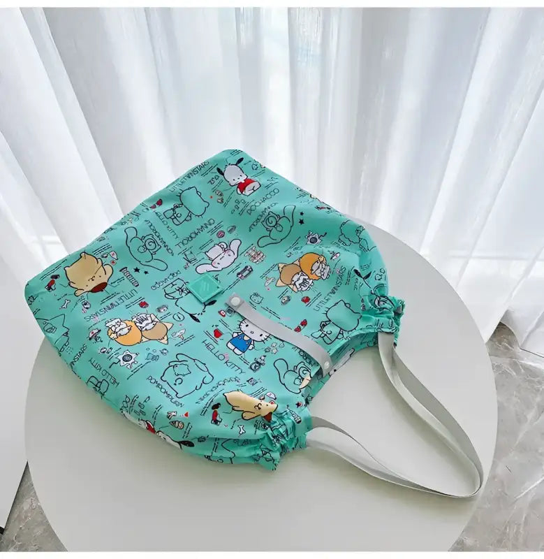 Turquoise cartoon-patterned drawstring tote bag.