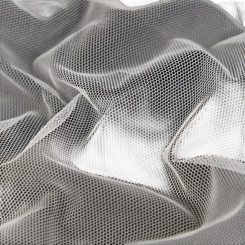 Wrinkled white hexagonal mesh fabric.