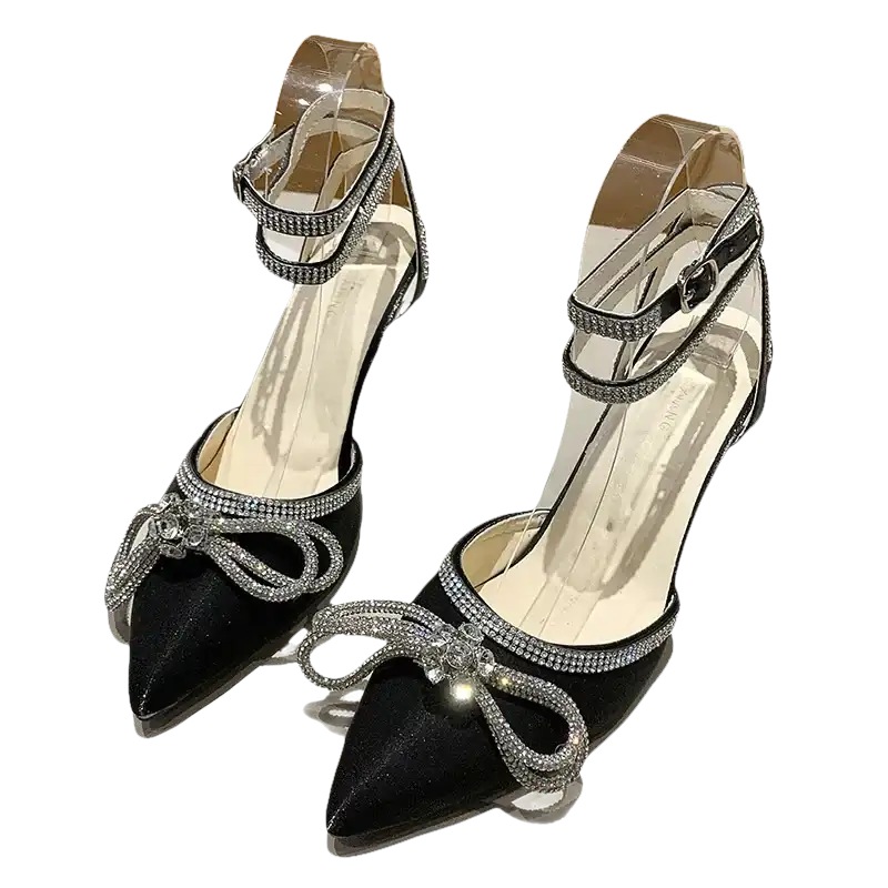 Black high-heeled shoes with rhinestone bows and ankle straps.