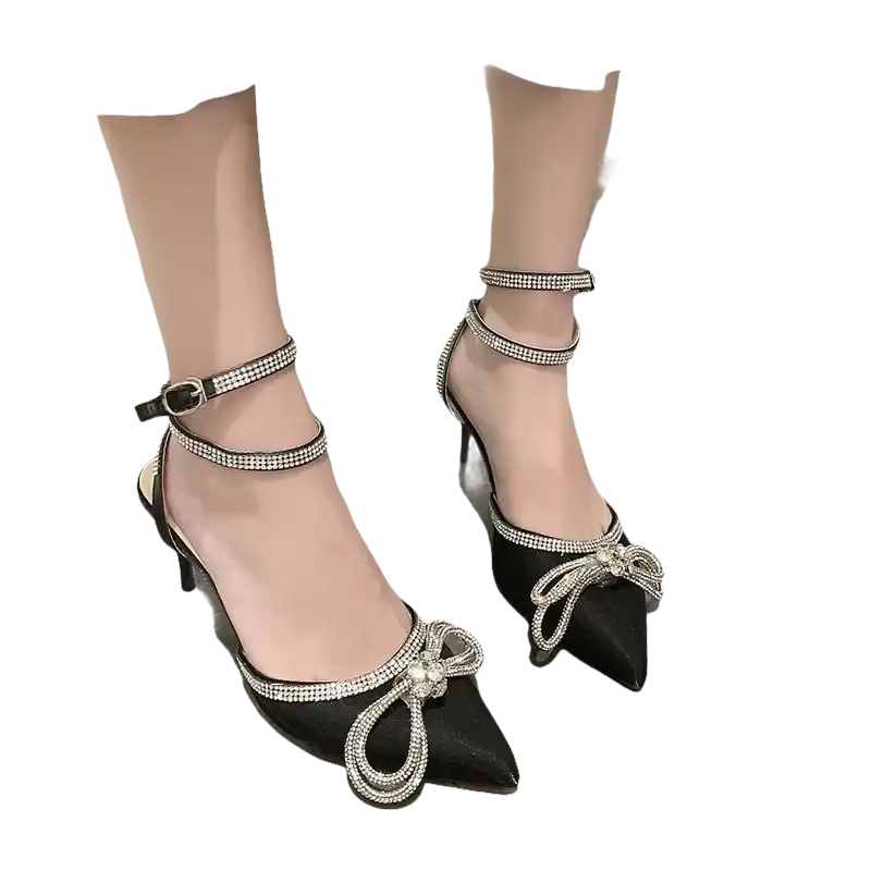 Black high heels with rhinestone bows and ankle straps.