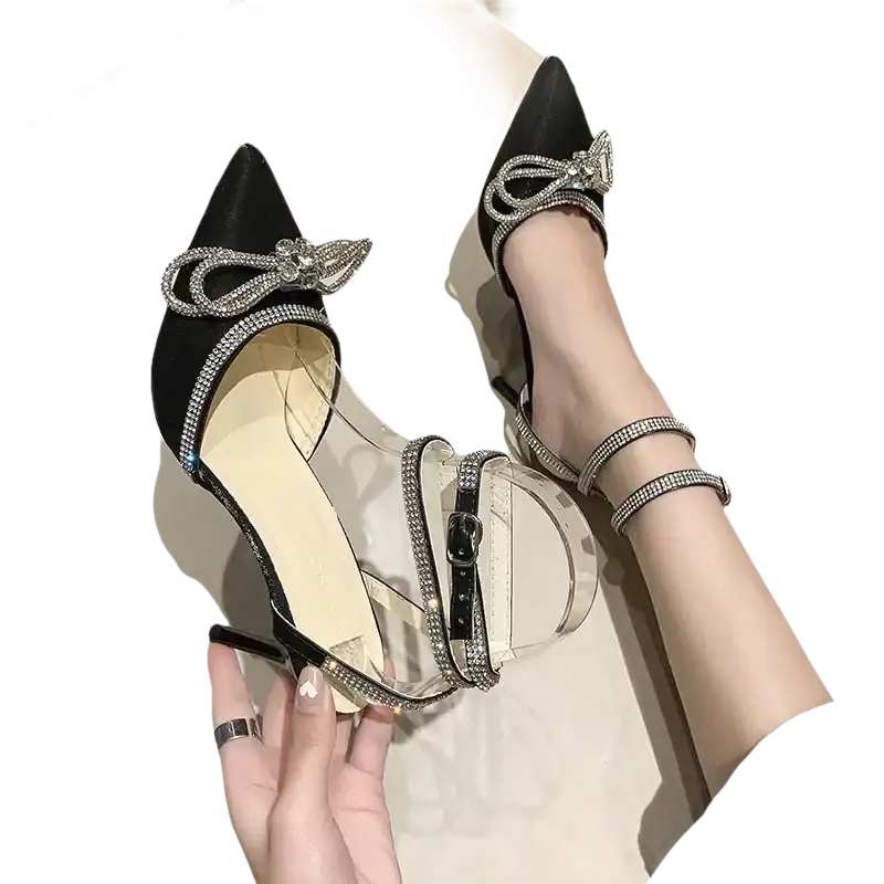 Black stiletto heels with rhinestone bows and clear straps.