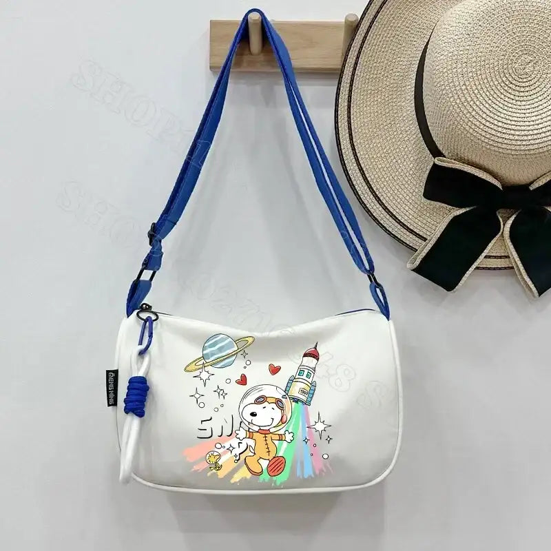 White shoulder bag with Snoopy astronaut design.