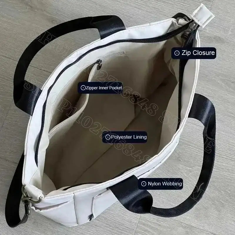White tote bag with black nylon webbing handles.