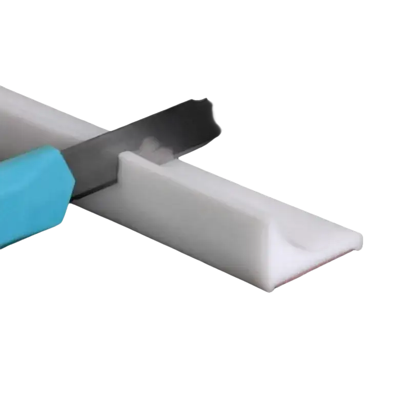 White adhesive-backed plastic strip being cut.
