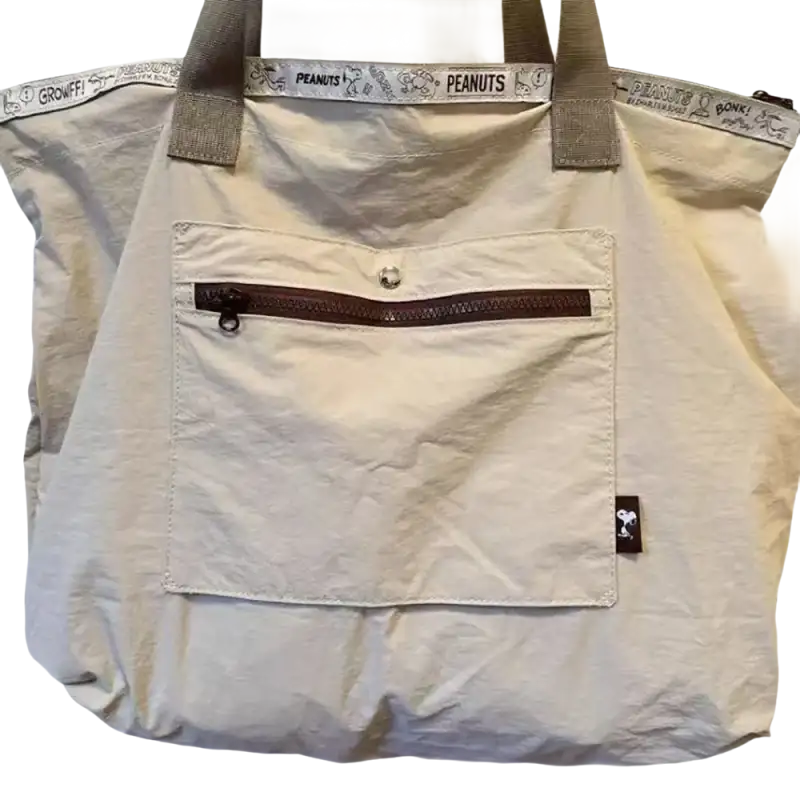 Beige tote bag with Peanuts trim.
