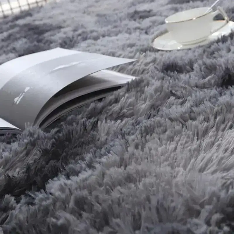 Gray shag rug with book and teacup showcasing trendy Vikama Tie-Dye Silk Wool rug