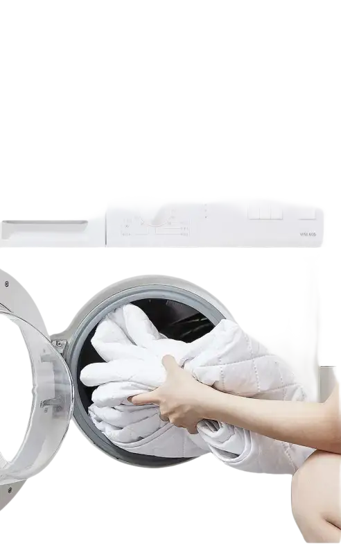 Mattress protector being loaded into a washing machine.