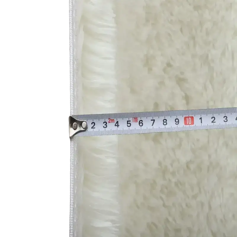 Fluffy white rug with measuring tape.