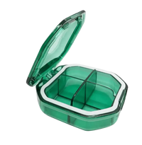 Green plastic pill organizer with four compartments.