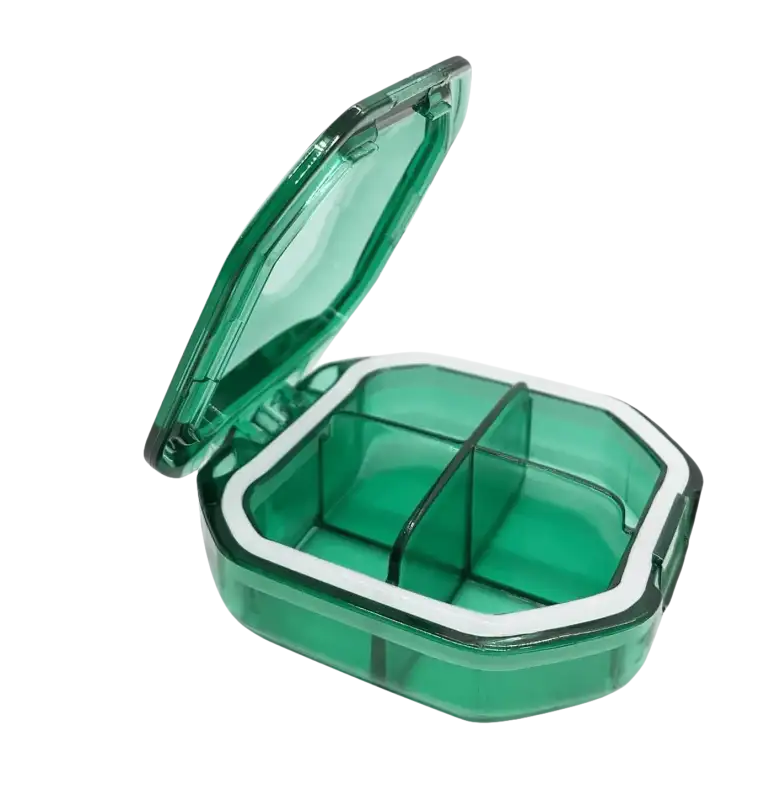 Green plastic pill organizer with four compartments.