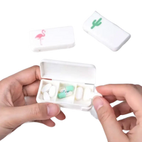 White pill organizer with flamingo and cactus designs.