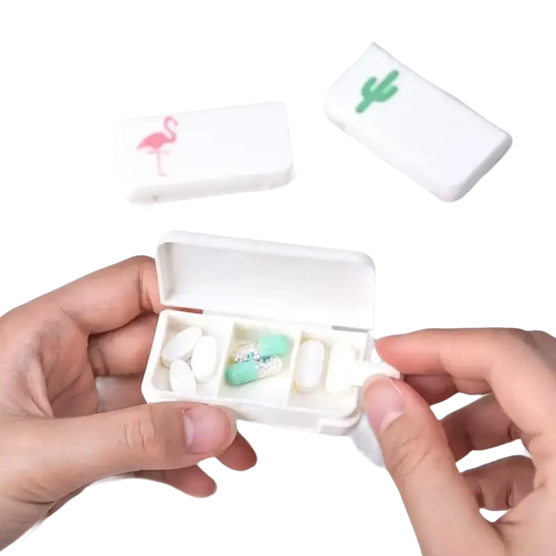 White pill organizer with flamingo and cactus designs.