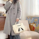 Gray wool coat with a Snoopy tote bag.
