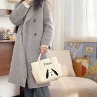 Gray wool coat with a Snoopy tote bag.