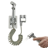 Chrome bidet sprayer with coiled hose.