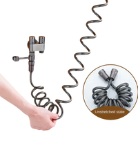 Coiled gray bidet hose with faucet.