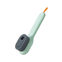 Green cleaning brush with gray bristles.