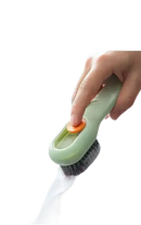 Green cleaning brush with orange button.