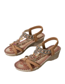 Tan wedge sandals with beaded embellishments.