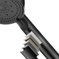 Black shower head with multiple paint layers.