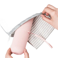 Pink ribbed water bottle in gray drawstring bag with Vertibrush Travel Kit and detangling hairbrush for trendy travel vibes