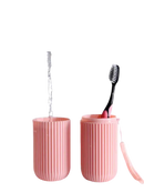 Pink split toothbrush cup with toothbrush and water from Vertibrush Travel Kit, trendy vibe