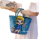 Blue woven tote bag with cartoon patch.