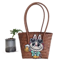 Brown woven tote bag with cartoon patch.