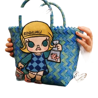 Blue woven tote bag with cartoon patch.