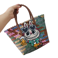 Woven tote bag with cartoon bunny patch.