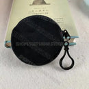 Round, dark-colored coin purse with black clasp.