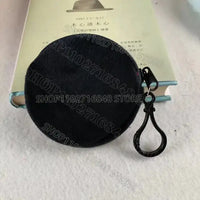 Round, dark-colored coin purse with black clasp.