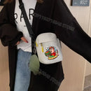 White crossbody bag with cartoon graphic.