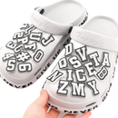 White clogs with letter charms.