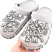 White clogs with letter charms.