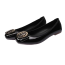 Pair of black patent leather ballet flats with gold embellishments.