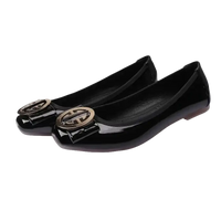 Pair of black patent leather ballet flats with gold embellishments.