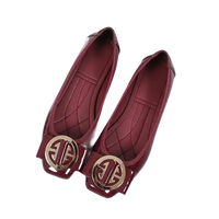 Pair of burgundy patent leather flats with gold embellishments.