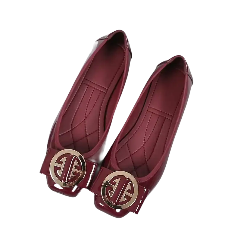 Pair of burgundy patent leather flats with gold embellishments.