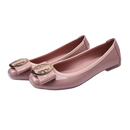 Pair of pink patent leather ballet flats with bow and gold emblem.