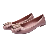 Pair of pink patent leather ballet flats with bow detail.