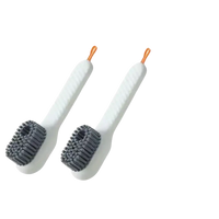 Two white shoe cleaning brushes.