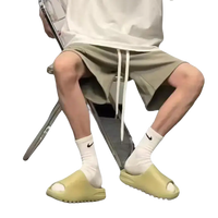 Person wearing slides and socks.