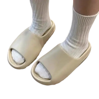 Beige slide sandals with white socks.