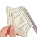 Beige quilted fabric pad with scissors.