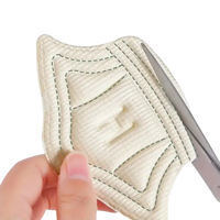 Beige quilted fabric pad with scissors.